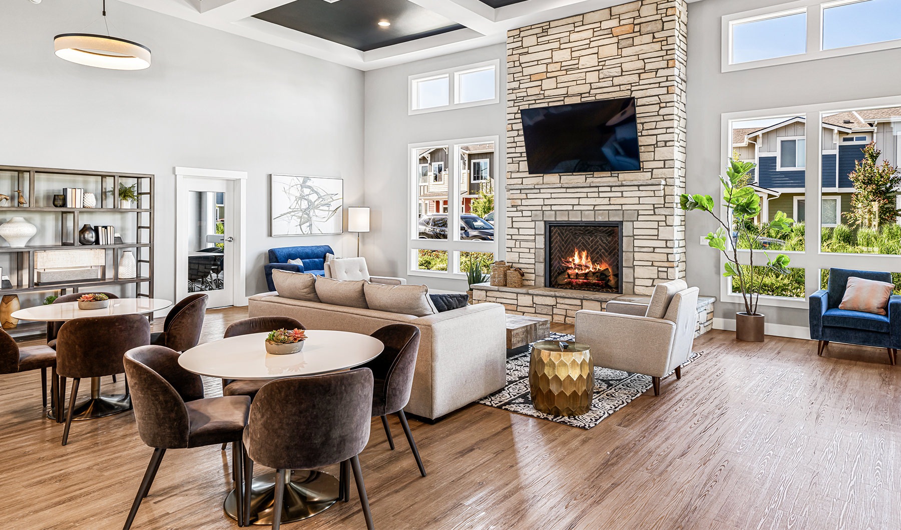 Resident clubhouse with ample seating, fireplace, demo kitchen and TVs
